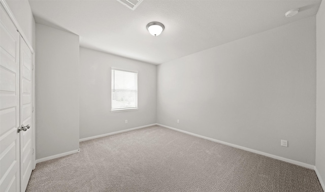 unfurnished bedroom with carpet, visible vents, and baseboards