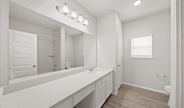 full bathroom featuring baseboards, toilet, vanity, and wood tiled floor