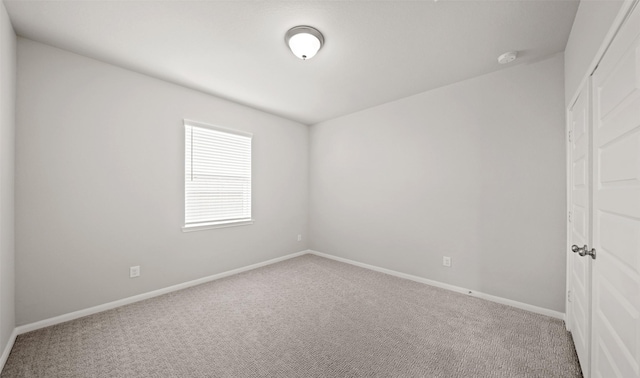 empty room featuring baseboards and carpet floors