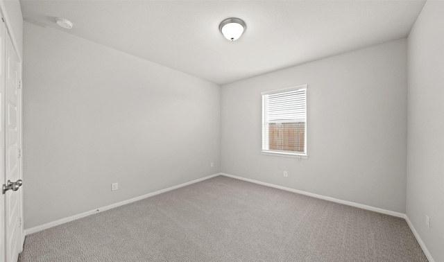 unfurnished room with baseboards and light carpet