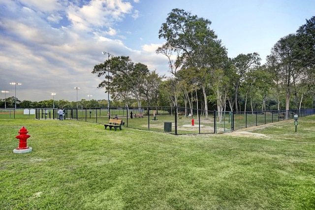 view of home's community with a lawn and fence