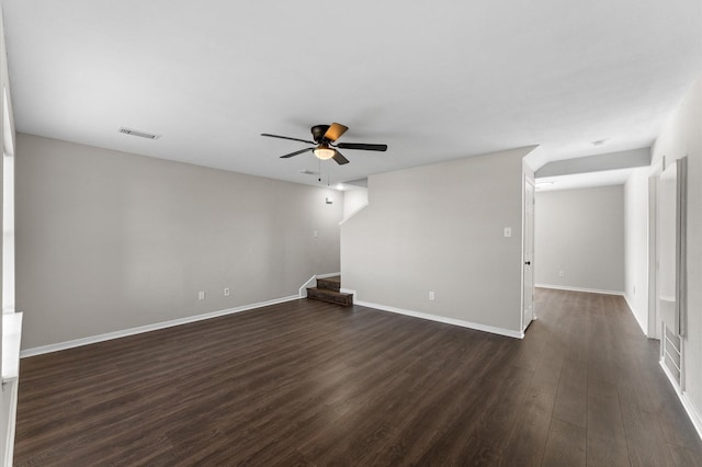 empty room with stairway, baseboards, visible vents, dark wood-style flooring, and ceiling fan