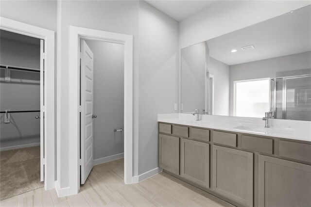357 Spruce Oak Ln, Waller, TX 77484 - bathroom featuring a walk in closet, a stall shower, baseboards, double vanity, and recessed lighting