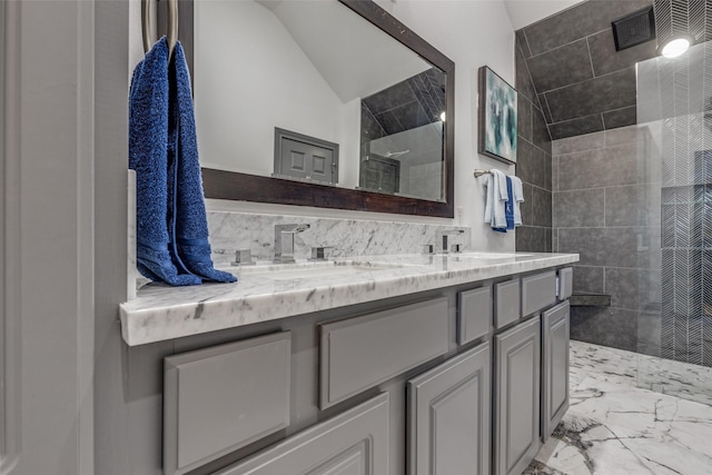 bathroom with double vanity, marble finish floor, walk in shower, and a sink