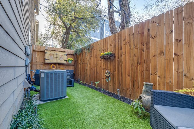 view of yard with central AC unit and fence