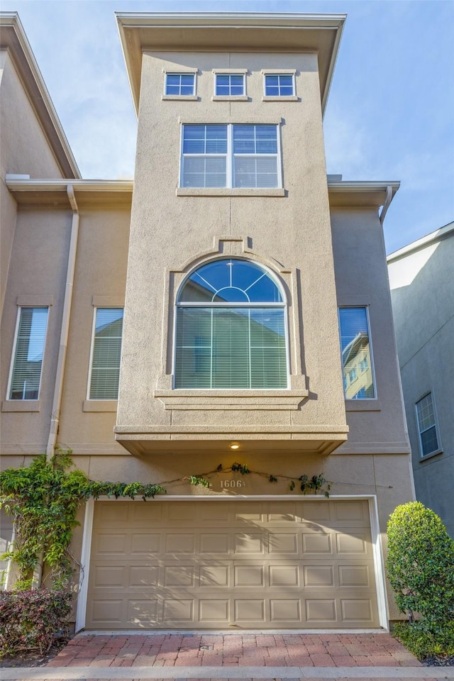 townhome / multi-family property with stucco siding and an attached garage