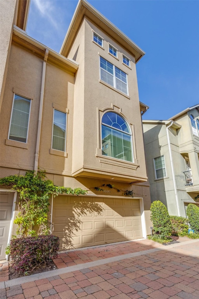 multi unit property with a garage and stucco siding