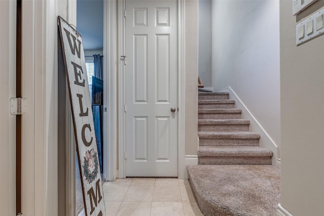 entryway with light tile patterned flooring and stairway