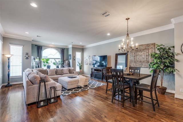 dining space featuring dark wood finished floors, crown molding, a notable chandelier, and baseboards