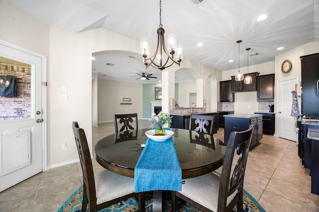 dining area with arched walkways, recessed lighting, ceiling fan with notable chandelier, and light tile patterned flooring