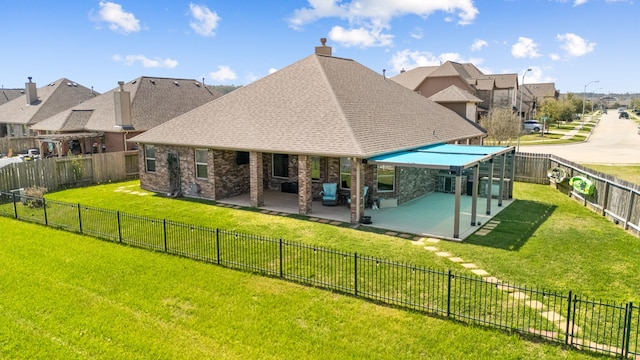 rear view of house featuring a residential view, a patio area, a lawn, and a fenced backyard