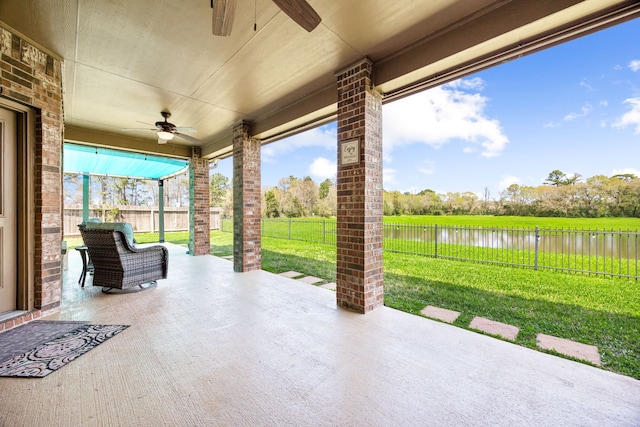 view of patio with ceiling fan, a water view, and a fenced backyard