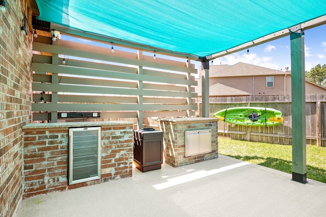 view of patio / terrace with exterior kitchen and fence