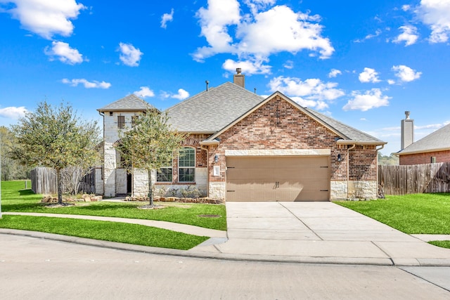 french country inspired facade featuring fence, an attached garage, a front lawn, concrete driveway, and brick siding