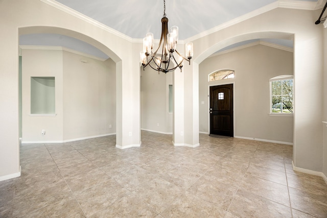 unfurnished room with an inviting chandelier, baseboards, and arched walkways