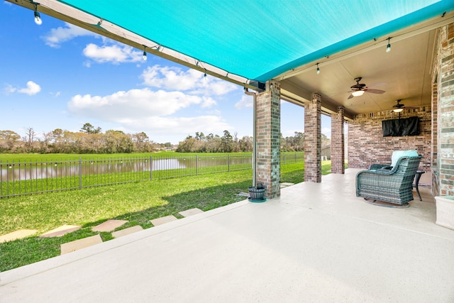 view of patio / terrace with a fenced backyard, a water view, and ceiling fan