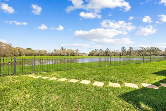 view of yard with a water view and fence