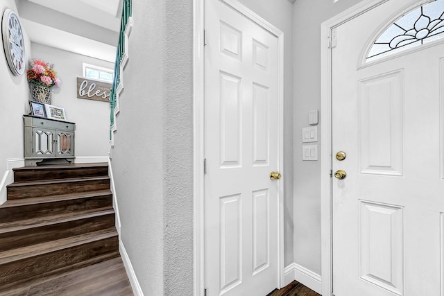 entrance foyer featuring stairway and baseboards