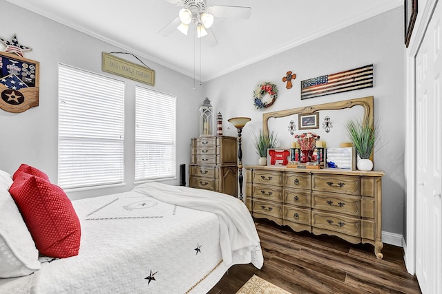 bedroom with crown molding, a ceiling fan, dark wood-style flooring, and a closet