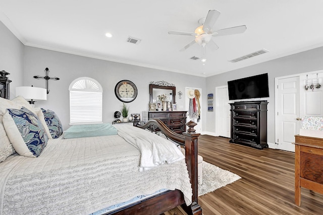 bedroom with ceiling fan, wood finished floors, visible vents, and ornamental molding