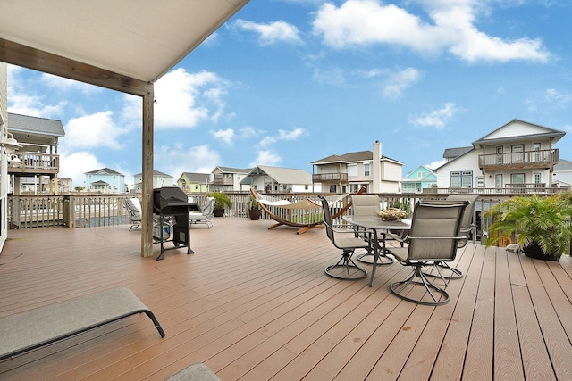 deck with a residential view, area for grilling, and outdoor dining space