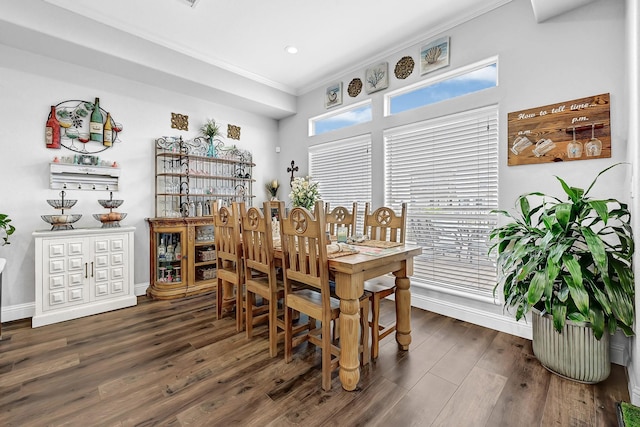 dining room with dark wood finished floors, crown molding, and baseboards