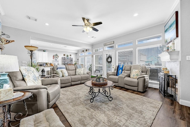 living area with a ceiling fan, visible vents, dark wood finished floors, recessed lighting, and ornamental molding