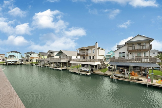 dock area with a residential view, a balcony, and a water view