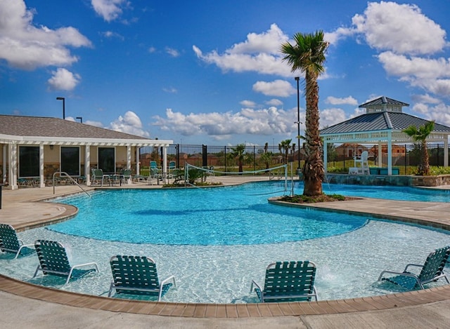 community pool with a patio and fence