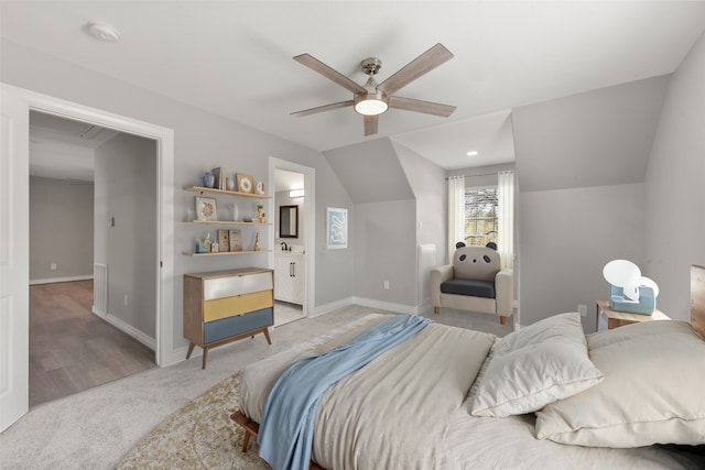 bedroom with light carpet, lofted ceiling, ensuite bath, baseboards, and ceiling fan