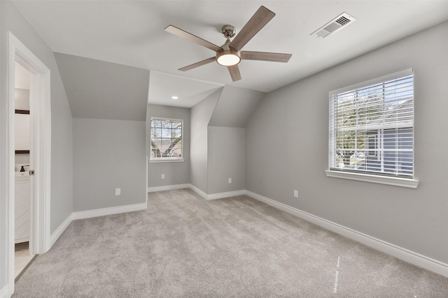 bonus room with visible vents, baseboards, light colored carpet, and ceiling fan