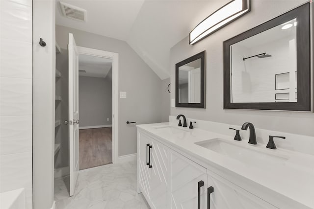 bathroom featuring visible vents, marble finish floor, lofted ceiling, and a sink