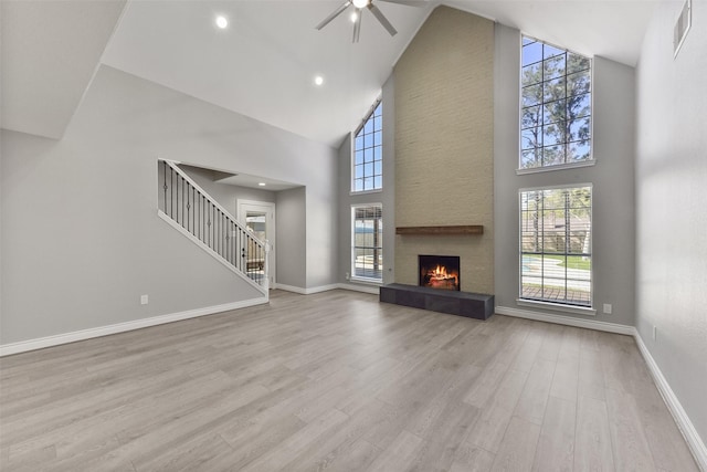 unfurnished living room featuring visible vents, a ceiling fan, wood finished floors, a fireplace, and baseboards