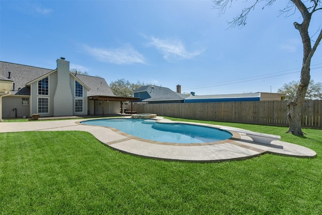 view of pool featuring a patio area, a yard, a fenced backyard, and a diving board