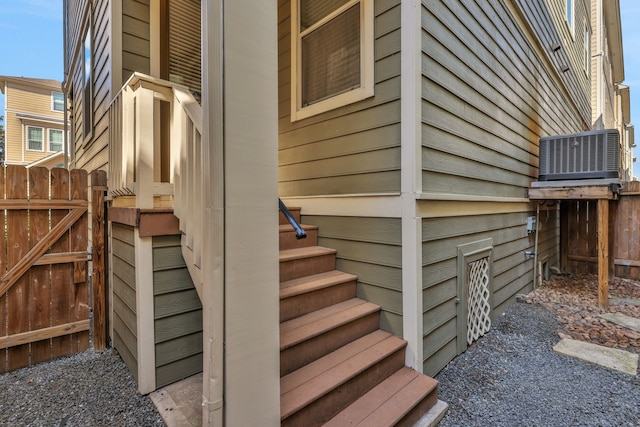 view of property exterior featuring central AC unit, a gate, and fence