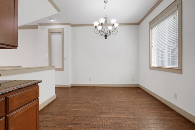 unfurnished dining area featuring a chandelier, baseboards, and ornamental molding