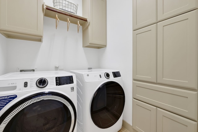 washroom featuring cabinet space and washing machine and clothes dryer