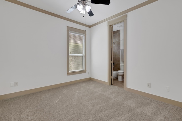 spare room featuring baseboards, light colored carpet, ornamental molding, and a ceiling fan