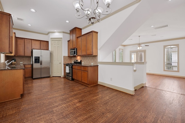 kitchen featuring visible vents, baseboards, ornamental molding, a sink, and appliances with stainless steel finishes