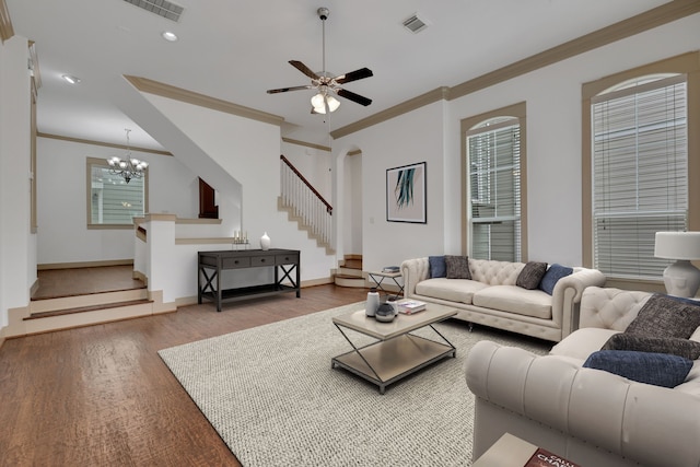 living room with visible vents, crown molding, stairs, and wood finished floors