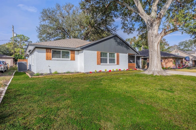 ranch-style house featuring a front yard, central AC unit, and brick siding