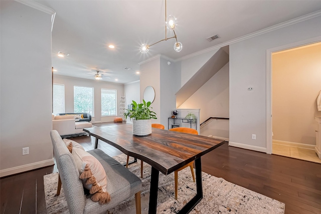 dining area featuring visible vents, ornamental molding, a ceiling fan, wood finished floors, and baseboards