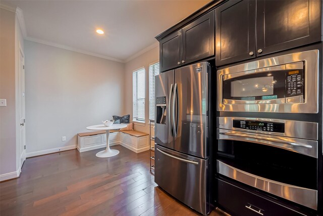 kitchen with ornamental molding, dark wood finished floors, stainless steel appliances, baseboards, and dark brown cabinets