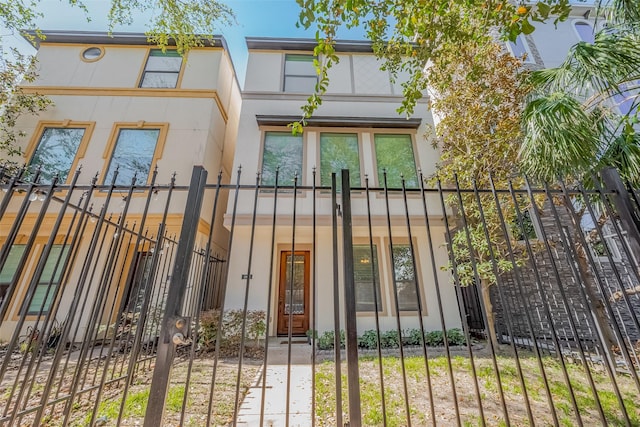 view of front of home featuring a fenced front yard and stucco siding