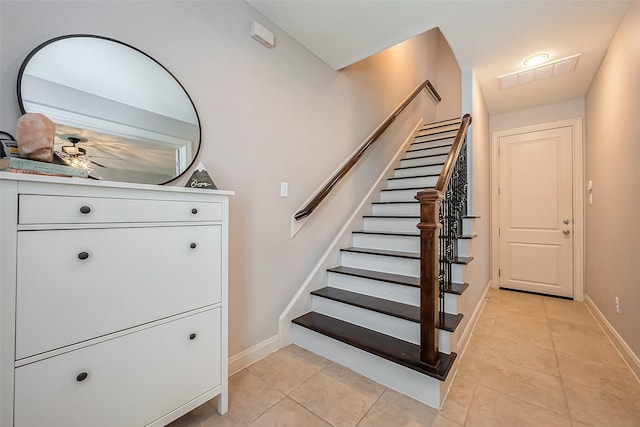 staircase featuring tile patterned flooring, visible vents, and baseboards