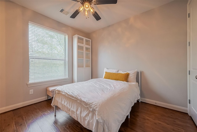 bedroom featuring visible vents, baseboards, wood finished floors, and a ceiling fan