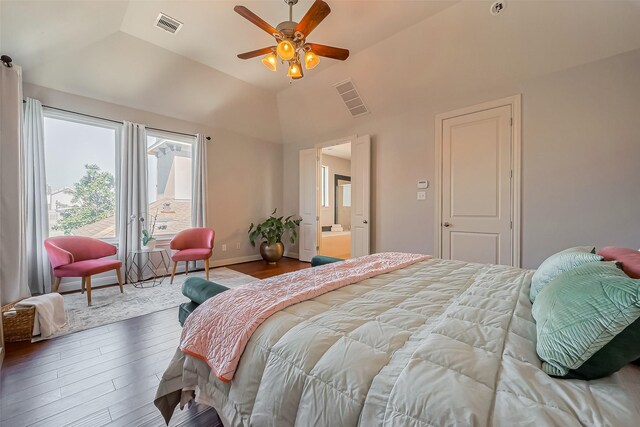 bedroom with lofted ceiling, wood finished floors, visible vents, and baseboards