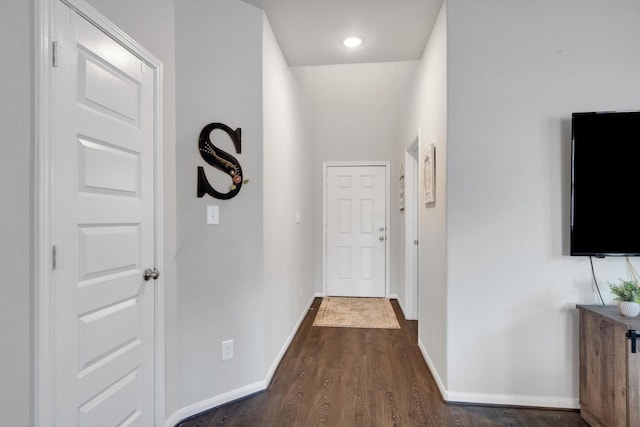 hallway featuring recessed lighting, dark wood-type flooring, and baseboards