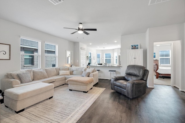 living room with a ceiling fan, visible vents, wood finished floors, baseboards, and recessed lighting