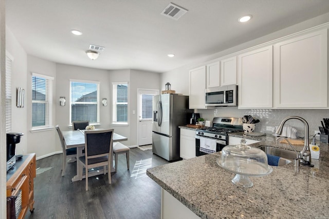 kitchen featuring visible vents, backsplash, appliances with stainless steel finishes, and white cabinets